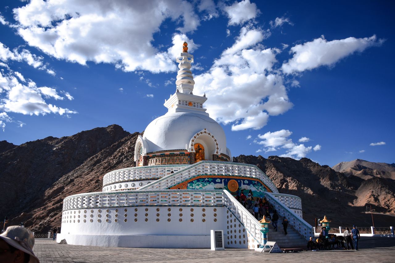 Capture of the Shanti Stupa against a stunning mountainous landscape in Leh under a clear blue sky.