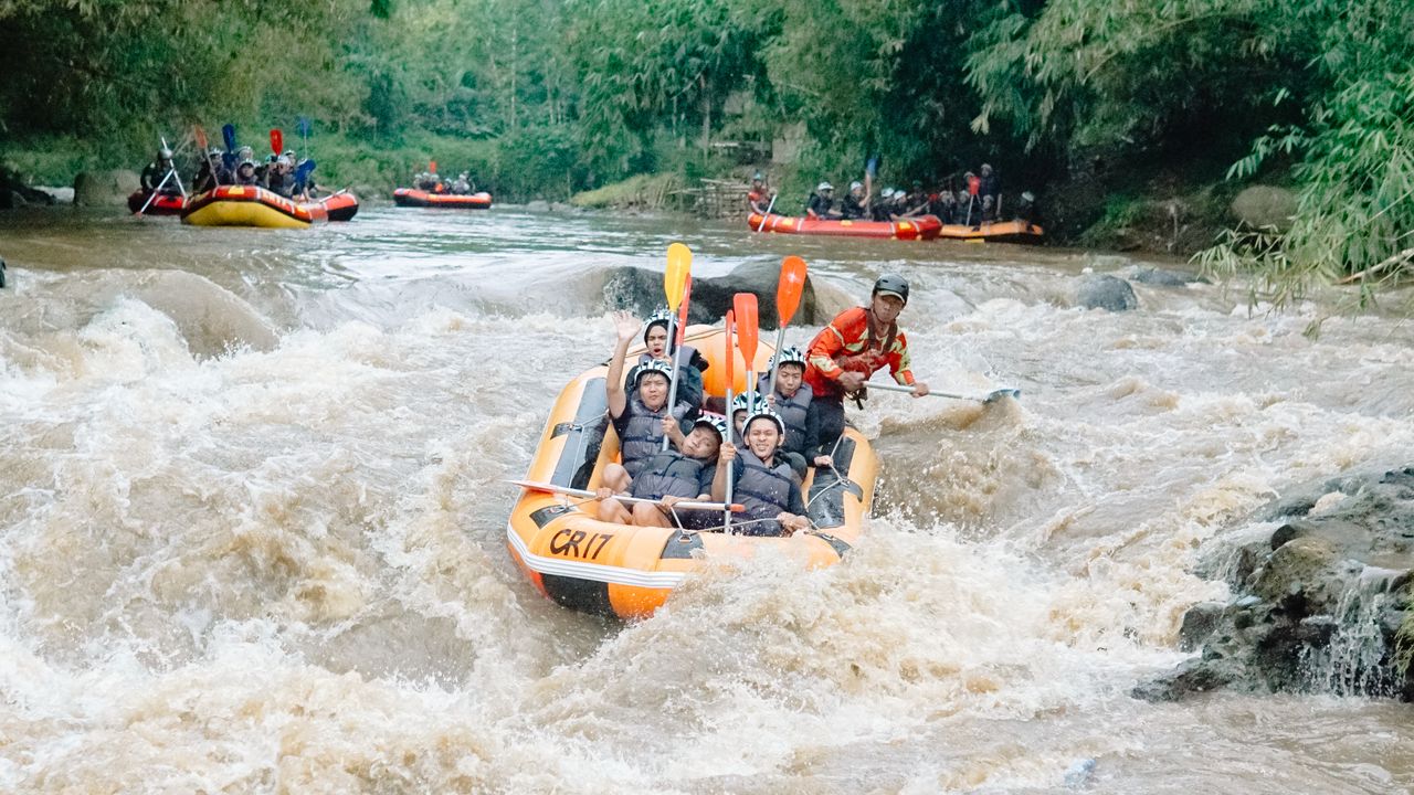 Exciting whitewater rafting with group navigating turbulent river in an inflatable raft amid lush greenery.